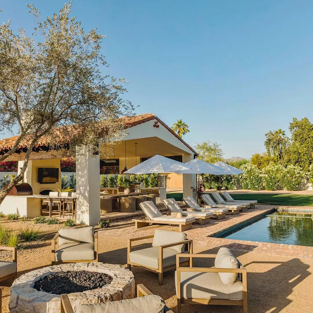 Outdoor living space with pool, fire feature, lounge seating, and planting