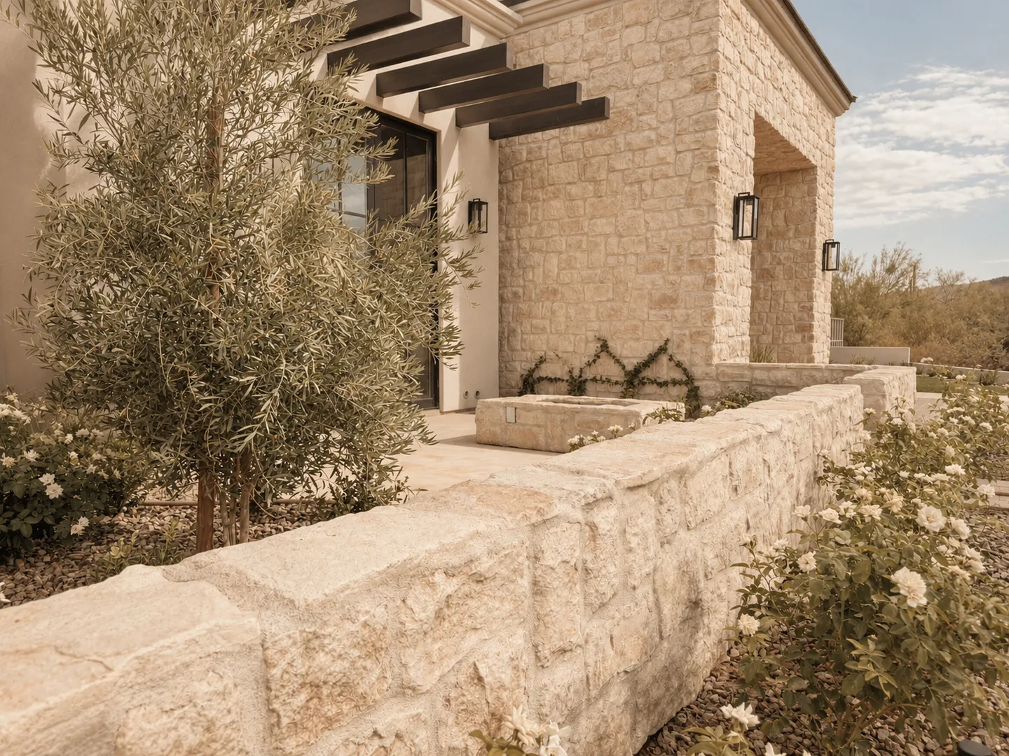 Concept image of a pale stone entry wall, olive tree, and desert planting